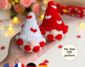 May include: Two handmade crochet gnomes, one white and one red, each adorned with red heart accents. The gnomes have beige faces and red feet. The image includes the text "No-Sew PDF pattern".