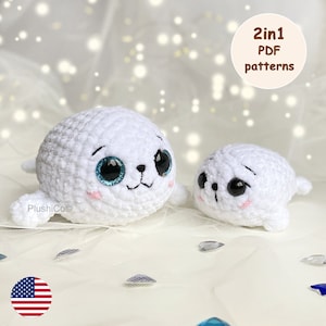May include: Two crocheted white seal plushies with black eyes and blue pupils. The larger seal is sitting up with its flippers outstretched. The smaller seal is lying down with its flippers tucked under its body. The text "2in1 PDF patterns" is written in brown text on a white circle in the upper right corner of the image.