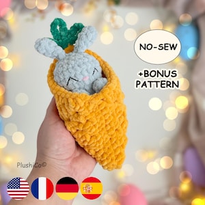 Puede incluir: Un conejito de peluche hecho a mano dentro de una zanahoria de ganchillo. El conejito es azul claro con los ojos cerrados, y la zanahoria es de color naranja brillante con hojas verdes. Incluye el texto "NO-SEW + BONUS PATTERN".