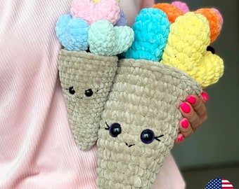 May include: Two crocheted ice cream cones with smiling faces. The cones are filled with colorful crocheted hearts in shades of pink, blue, yellow, and orange.