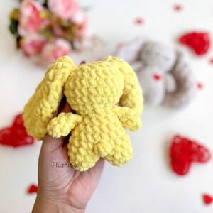 May include: A yellow crocheted bunny with long ears. The bunny is made of soft, fuzzy yarn and has a sweet, cuddly appearance.