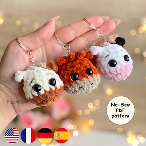 May include: Three handmade crochet animal keychains in white, orange, and white with brown accents. Each keychain features a silver ring and a cute animal face with large black eyes. The keychains are soft and plush, perfect for adding a touch of whimsy.