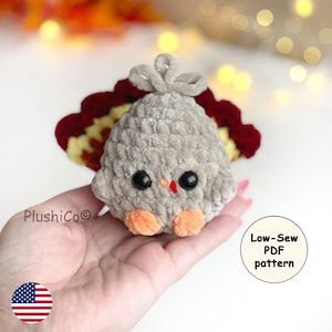 May include: A handmade plush turkey with a gray body, black eyes, and an orange beak and feet. The turkey has a red, yellow, and brown tail. The text "Low-Sew PDF pattern" is in a white circle. The product is a craft item.