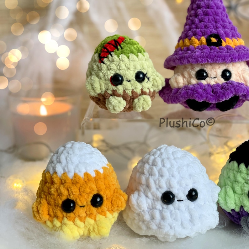 Puede incluir: Una colecci&oacute;n de peluches de ganchillo hechos a mano con tem&aacute;tica de Halloween. Los peluches incluyen un zombi, una bruja, un caramelo de ma&iacute;z y un fantasma. Cada peluche tiene ojos de seguridad negros y una cara sonriente. El fondo est&aacute; borroso con un brillo suave y c&aacute;lido.