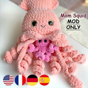 Puede incluir: Un juguete de pulpo rosa de felpa hecho a mano con un pulpo rosa más pequeño anidado en su interior. El pulpo más grande tiene ojos con borde dorado y el texto "Mom Squid MOD ONLY". Un juguete suave y tierno para niños.