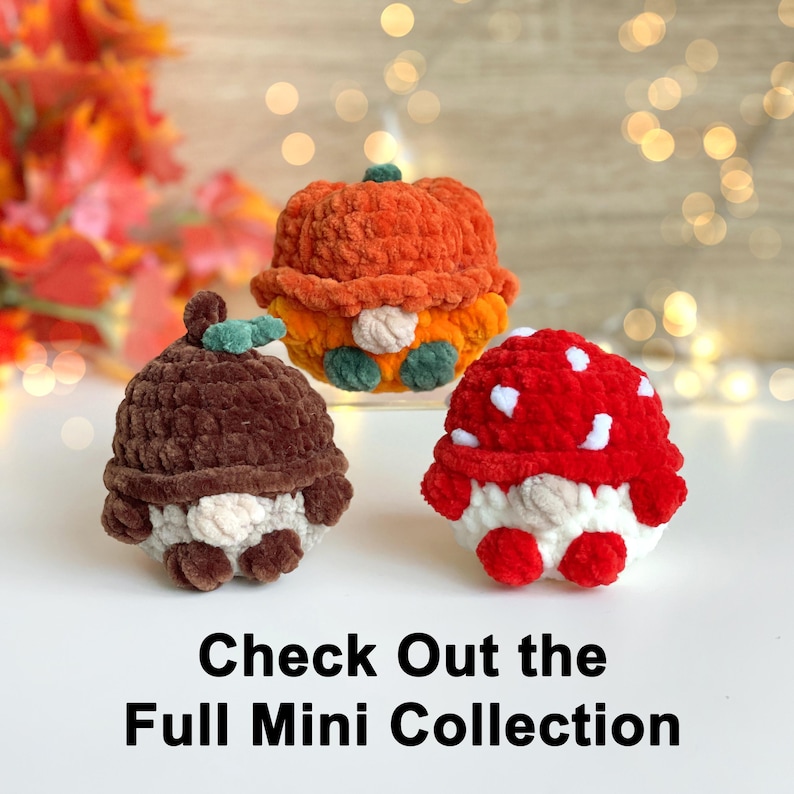 May include: Three small crocheted plush figures featuring a brown acorn, an orange pumpkin, and a red mushroom with white spots. Each figure has a round body and a small nose. The text below reads: Check Out the Full Mini Collection.