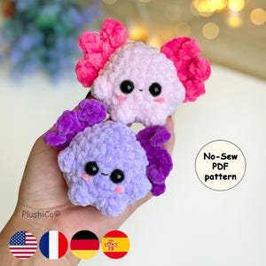 Könnte beinhalten: Zwei handgefertigte Plüsch-Axolotl in Rosa und Lila, mit großen schwarzen Augen und lächelnden Gesichtern. Der rosa Axolotl hat leuchtend rosa Kiemen, und der lila hat lila Kiemen. Der Text "No-Sew PDF pattern" befindet sich in einem weißen Kreis.