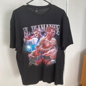 May include: Black t-shirt with a graphic print of three boxers. The text "El Diamante" and "Pain in Full" are printed on the shirt.