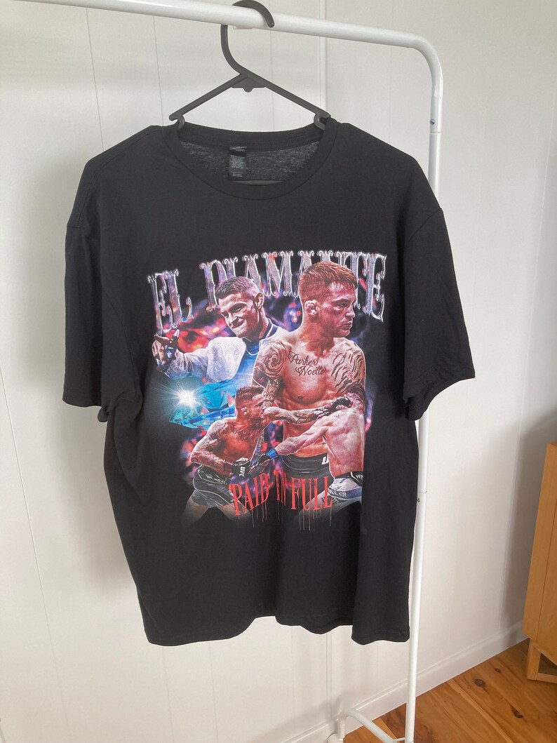 May include: Black t-shirt with a graphic print of three boxers. The text "El Diamante" and "Pain in Full" are printed on the shirt.