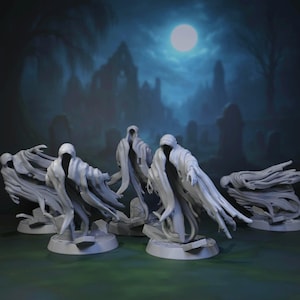 Puede incluir: Una colección de figuras de fantasmas blancos con capucha y brazos extendidos. Las figuras están situadas sobre un fondo de cementerio bajo la luna llena. Las figuras fantasmales están sobre bases circulares.