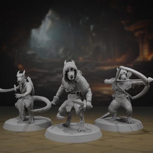 May include: Three grey fantasy figurines of humanoid creatures. One holds a sword, another a sword, and the third a bow and arrow. Each figure is posed on a circular base, with a blurred background.