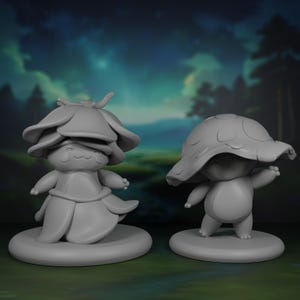 Könnte beinhalten: Zwei graue, stilisierte Figuren von Kreaturen mit pilz- und blütenartigen Merkmalen. Eine trägt einen blütenförmigen Hut, die andere eine Pilzkappe. Sie stehen auf runden Sockeln vor einem verschwommenen Waldbild.