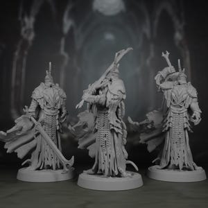 Puede incluir: Tres figuras grises en miniatura de guerreros con armadura, cada uno sosteniendo una espada. Las figuras tienen armaduras, cascos y capas detalladas. Se paran sobre bases circulares, con un fondo borroso.