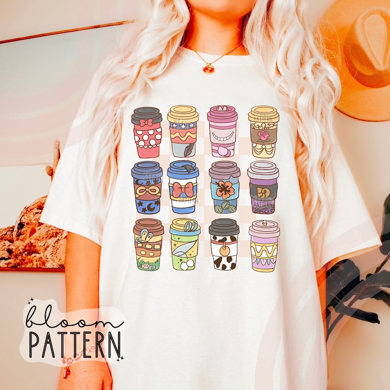May include: White t-shirt with a pattern of 16 colorful coffee cups. Each cup has a different design inspired by popular Disney characters. The text "bloom pattern" is printed on the bottom left corner of the shirt.