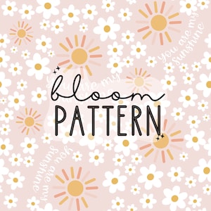 May include: A light pink floral pattern with white daisies and gold suns. The words "bloom PATTERN" are in the center, with "you are my sunshine" in a script font. The design is a repeating pattern.