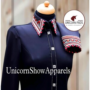 May include: A black long-sleeve shirt with a red, white, and black embellished collar and matching cuff. The shirt has a button-up front and is adorned with silver rhinestones. The text "UnicornShowApparels" is printed on the front of the shirt.