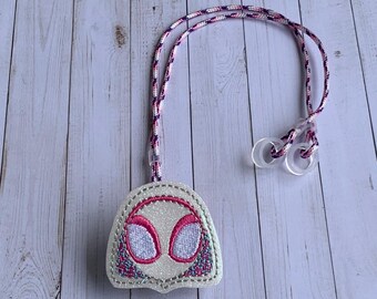 Peut inclure: Un porte-clés en forme de masque de Spider-Gwen blanc et rose avec un cordon assorti. Le porte-clés présente un visage blanc scintillant avec des détails d'yeux roses et une bordure cousue violette et rose. Le cordon a des boucles en plastique transparent.