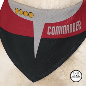 May include: A red, black, and gray dog bandana with four yellow circles and the word "COMMANDER" printed in white.