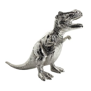 Może przedstawiać: Srebrna figurka dinozaura w pozycji stojącej. Dinozaur ma długi ogon i fakturowaną powierzchnię.