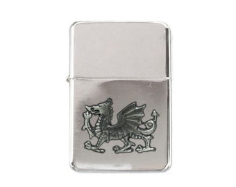 May include: A silver lighter with a silver dragon design on the front.
