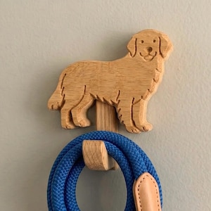 May include: A wooden dog-shaped wall hook with a blue dog leash hanging from it. The hook is carved in the shape of a Golden Retriever. The leash is a vibrant blue color with a tan leather accent.