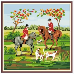 May include: Two people in red jackets ride horses through a green field with trees in the background.  There are three dogs running behind the horses.