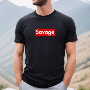 May include: A black t-shirt with a red box that says "Savage" in white letters.