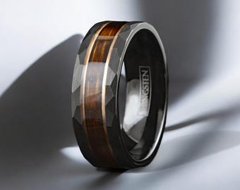 May include: A black tungsten ring with a brown wood inlay and a beveled edge. The ring is engraved with the word "TUNGSTEN".