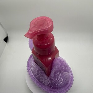 May include: A white ceramic mug with a black handle and the text "But First, Coffee" in a black, handwritten-style font. The mug is on a white surface.