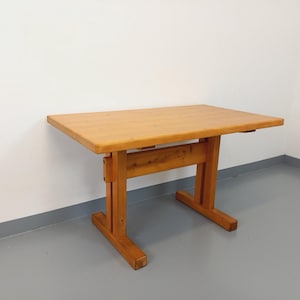 May include: A rectangular wooden table with a light brown finish. The table has a simple design with a flat top and sturdy legs. The table measures approximately 48 inches long and 30 inches wide.