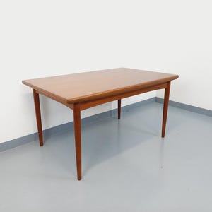 May include: A rectangular wooden table with a light brown finish. The table has four tapered legs and a simple, clean design. The table measures approximately 48 inches long and 28 inches wide.