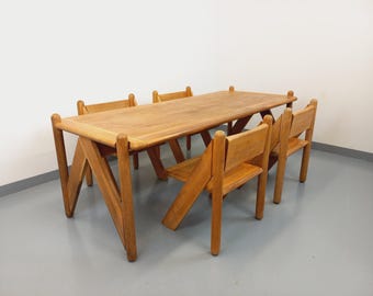 Könnte beinhalten: Ein hellbrauner Esstisch aus Holz mit rechteckiger Tischplatte und vier passenden Stühlen. Der Tisch hat angewinkelte Beine und die Stühle haben ein einfaches Design mit Lattenrücken. Das Set ist aus Holz gefertigt.