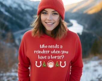May include: Red hoodie with a white graphic that says "Who needs a reindeer when you have a horse?" with two horseshoes and a Christmas tree on either side of a Santa Claus graphic.