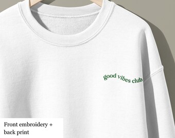 May include: White sweatshirt with green embroidered text that reads "good vibes club".