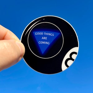 May include: A black and white 8-ball with a blue triangle that says "GOOD THINGS ARE COMING" inside.