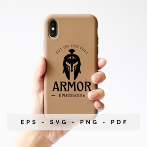 May include: A tan phone case with a black Spartan helmet design and the word "ARMOR". The text "Ephesians 6" is below the word "ARMOR". The phrase "PUT ON THE FULL" is above the helmet. The case is held in a hand.