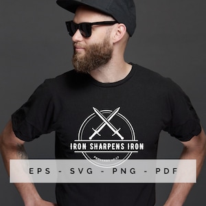 Puede incluir: Una camiseta negra con un diseño gráfico blanco de dos espadas cruzadas en un círculo con el texto "Iron Sharpens Iron" y "Proverbios 27:17".