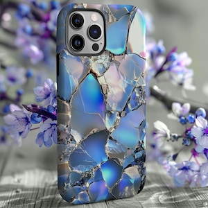 May include: A blue and white phone case with a cracked glass design. The case has a camera lens cutout and a raised lip around the edges.