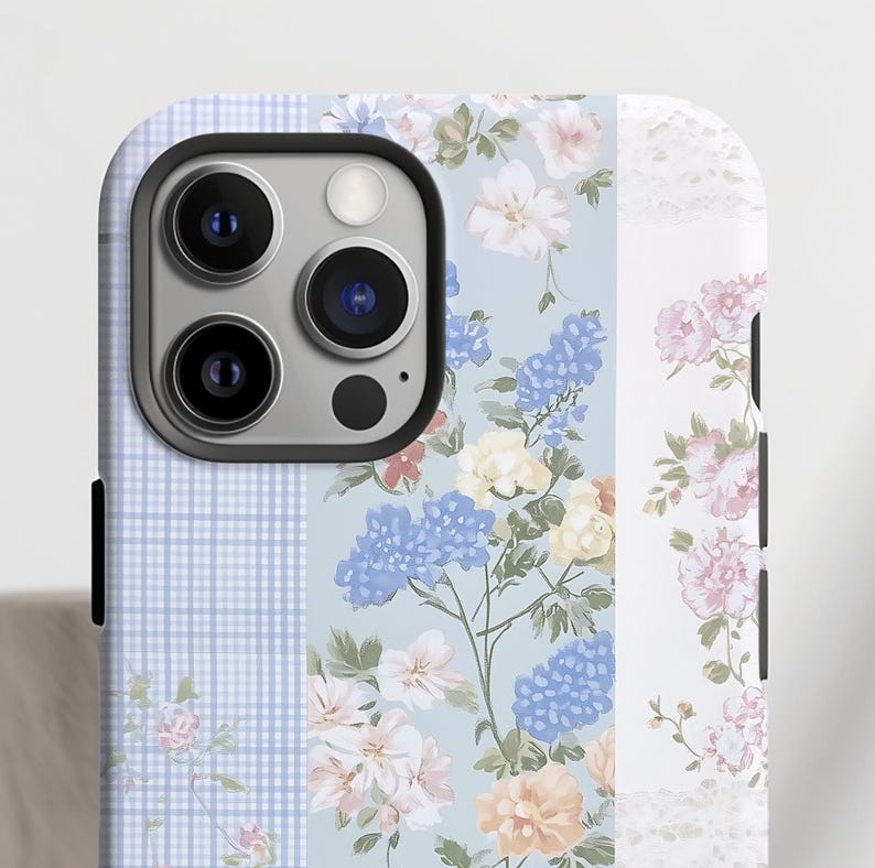 May include: A blue and white floral phone case with a checkered pattern and a white lace design. The case has a cutout for the camera lens.