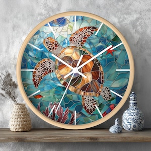 May include: Round wall clock with a light wood frame. The clock face features a stained glass design of a sea turtle swimming in blue water with a red starfish and fish. White clock hands and markers.