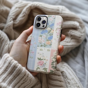 May include: A phone case with a patchwork design featuring floral patterns in shades of blue, pink, and green. The case has a clear camera lens cutout.