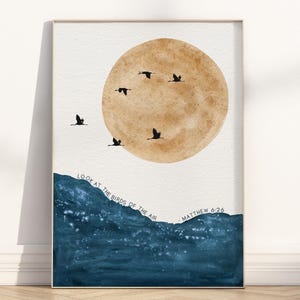 Könnte beinhalten: Aquarell-Kunstdruck mit einer großen, braunen Sonne und mehreren schwarzen Vögeln im Flug. Unter der Sonne befindet sich eine Darstellung von blauem Wasser. Der Text "LOOK AT THE BIRDS OF THE AIR" und "MATTHEW 6:26" ist enthalten.