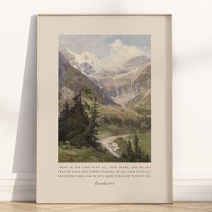 May include: Framed art print featuring a landscape painting of a mountain valley with a river and waterfalls. The artwork has a vintage aesthetic with text at the bottom that reads "Trust in the Lord... Proverbs 3:5-6."