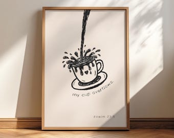 May include: A framed art print featuring a black and white illustration of a coffee cup overflowing with liquid. The words "my cup overflows" and "psalm 23:5" are written on the print. The frame is made of wood.