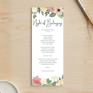 May include: A vertical white program with the title "Night of Belonging" in elegant script. Floral watercolor accents in pink, yellow, and green adorn the top and bottom. The program lists event details.