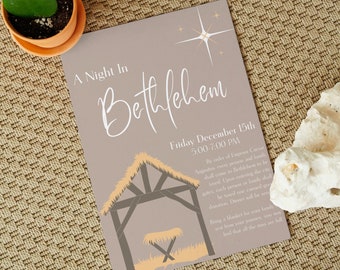 Może przedstawiać: Beżowa karta zaproszenia z białą gwiazdą i tekstem "A Night in Bethlehem" w białym, ozdobnym piśmie. Karta zawiera również brązowo-beżową ilustrację stajni z żłóbkiem w środku. Tekst pod ilustracją brzmi "Friday December 15th 5:00-7:00 PM" i zawiera opis rozporządzenia o spisie ludności wydanego przez cesarza Augusta.