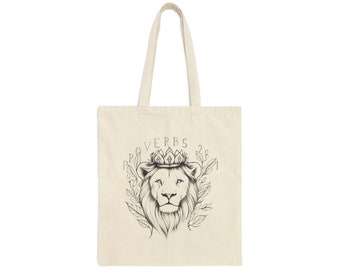 May include: A beige tote bag with a black and white illustration of a lion wearing a crown. The text "Proverbs 28:1" is printed above the lion.