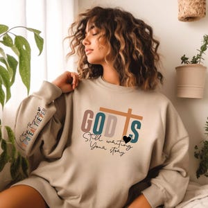 God is Still writing your Story Sweatshirt, Christian Hoodie,Bible Verse Shirts,Woman Christian Clothing, Front Sleeve Print,Christian Gifts