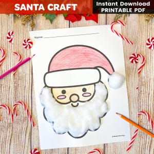 Op de afbeelding: Een knutselafdruk van de kerstman met een rode muts en een baard van watten. De woorden "SANTA CRAFT" en "Instant Download PRINTABLE PDF" staan bovenaan. Zuurstokken en potloden omringen het knutselwerk.