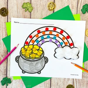 May include: A St. Patrick's Day themed craft project featuring a rainbow with colorful pom-poms, a pot of gold, and a fluffy cloud. The image includes a blank space for a name and is surrounded by green paper and gold coins.